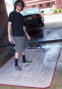 Photo of William Gantt cleaning dog smell off a carpet at the Kirkwood Car Wash.