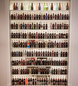 Wall of different Coca-Cola bottles in the Goizueta Foundation office