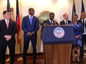 Atlanta Mayor Kasim Reed joyfully declares the city's $175 million in reserves as his CFO Jim Beard (in a blue suit) looks on (Photo by Maria Saporta)