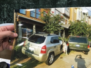 John Morgan came to Atlanta City Council to ask for improvements to DeKalb Avenue. He carried a picture of a car that crashed into his neighbor's porch on DeKalb. Credit: Maggie Lee