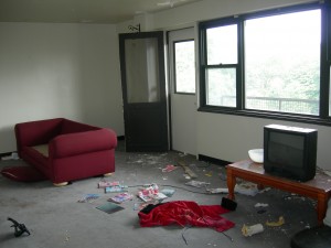 Our living/dining room with the door leading out to the balcony. Trash is left over from last tenant.